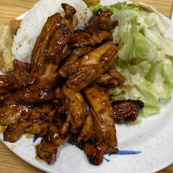 Niko Teriyaki's chicken teriyaki with white rice, gyoza, and a side salad with dressing.