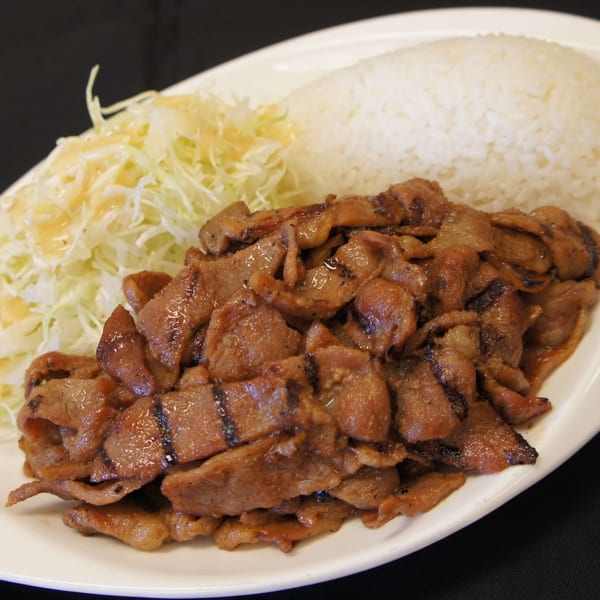 Niko Teriyaki's grilled pork teriyaki with white rice and shredded cabbage salad on a white plate.